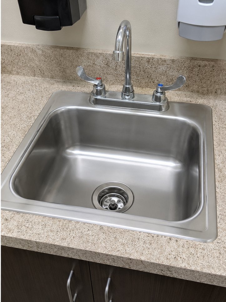The same commercial kitchen sink polished after cleaning